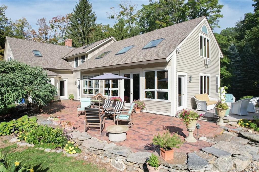 a front view of a house with garden and sitting area