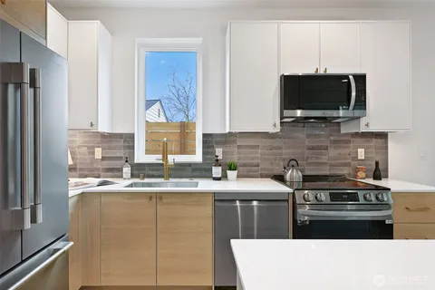 a kitchen with stainless steel appliances a stove microwave and sink