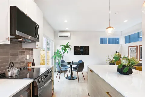 a kitchen with stainless steel appliances a microwave a sink a stove and a wooden floor