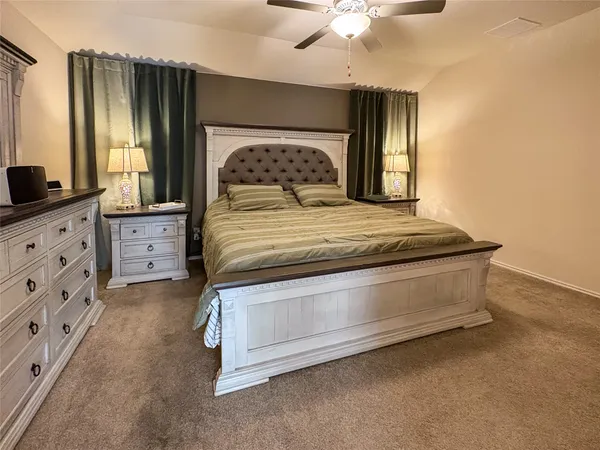 a spacious bedroom with a bed and a flat screen television