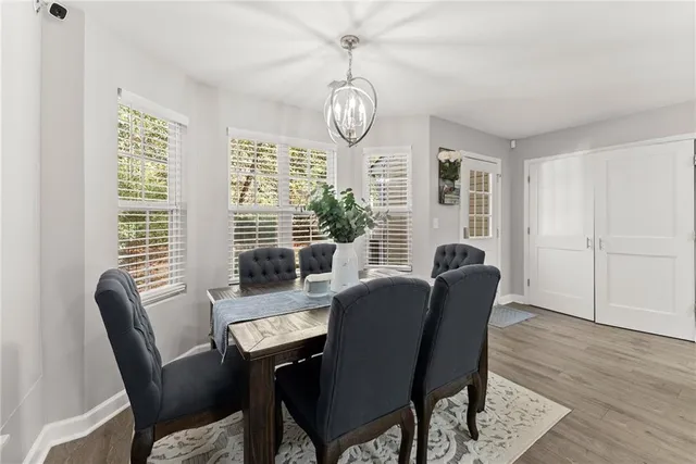 a dining room with furniture a chandelier and wooden floor