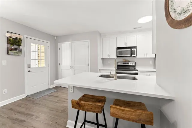 a kitchen with appliances a stove a table and chairs in it