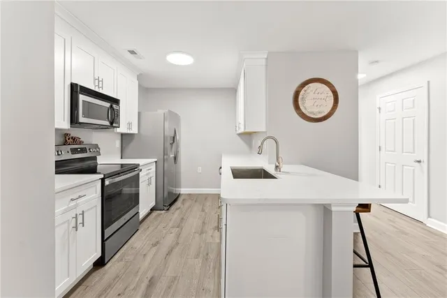 a kitchen with a sink appliances and cabinets