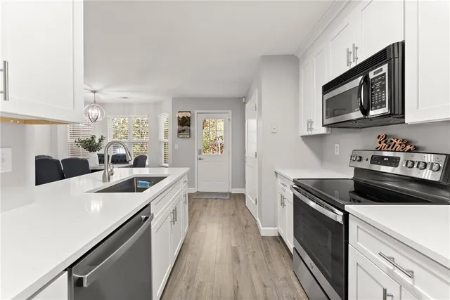 a kitchen with stainless steel appliances granite countertop a sink stove and microwave
