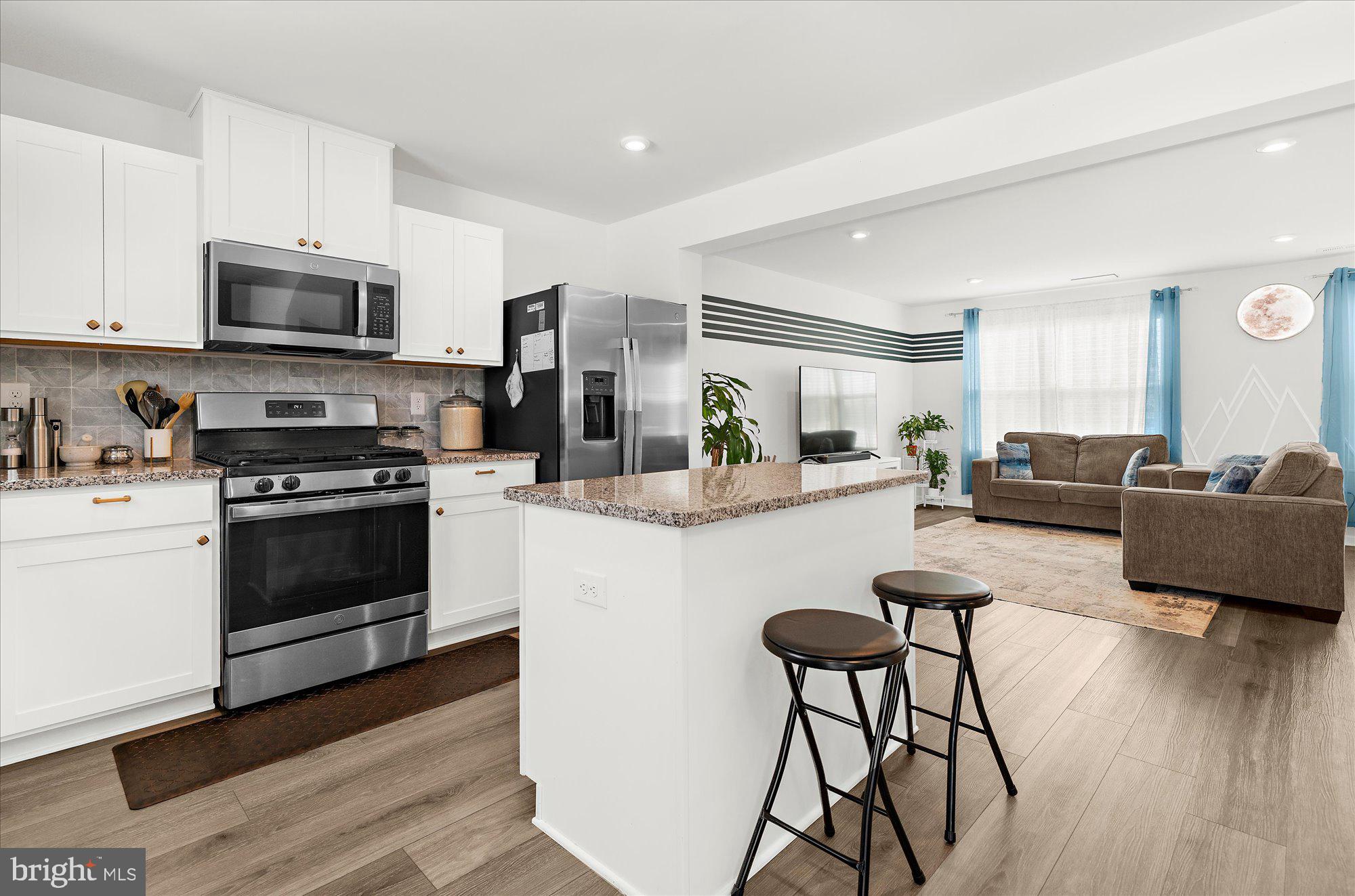 39 Wendowski Street Beverly, NJ 08010 - Photo 4 of 25 a kitchen with stainless steel appliances a stove a sink dishwasher a refrigerator and a dining table with wooden floor
