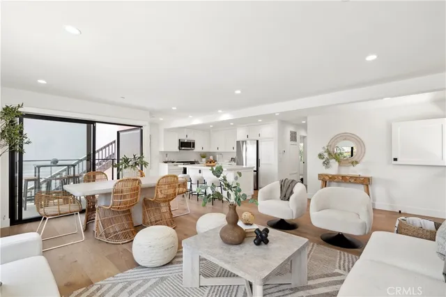 a living room with furniture a large window and wooden floor