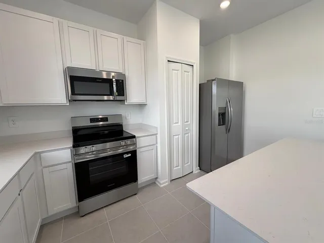 a kitchen with stainless steel appliances a stove microwave and sink