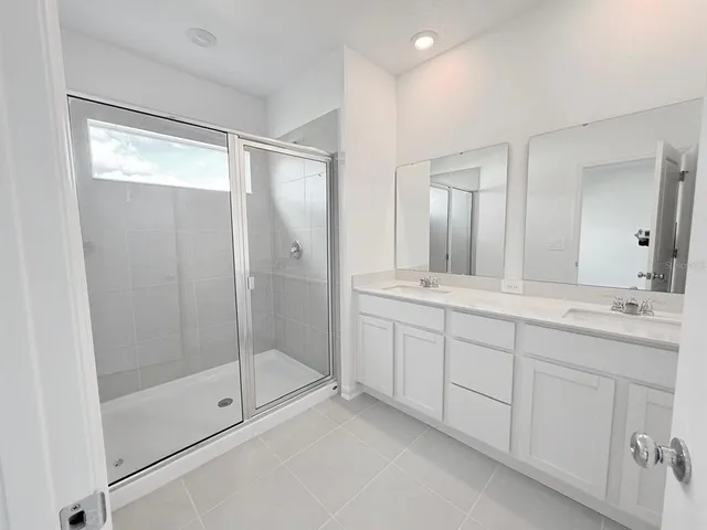 a bathroom with double sink and a mirror