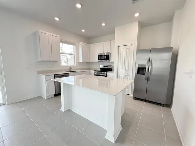 a kitchen with stainless steel appliances granite countertop a refrigerator sink and cabinets