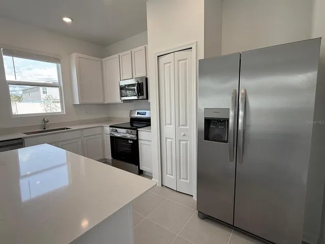 a kitchen with a refrigerator and a sink