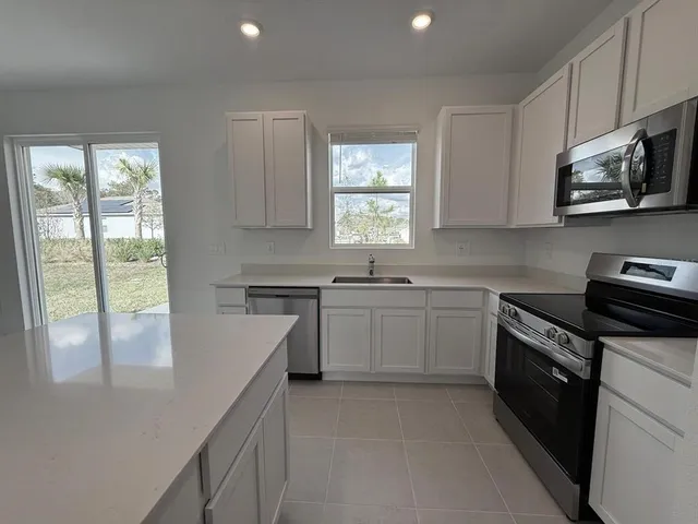 a kitchen with a sink stove oven and window