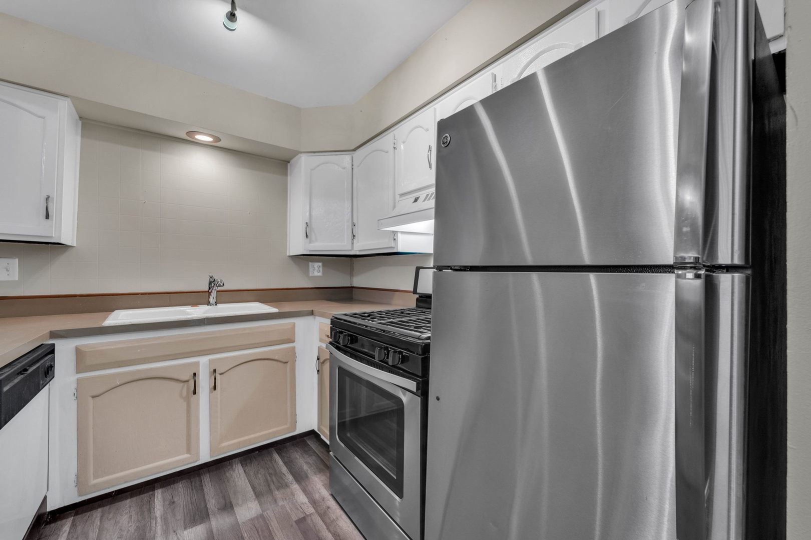 239 North Mill Road, Unit 104A Addison, IL 60101 - Photo 4 of 14 a kitchen with a sink a refrigerator and cabinets