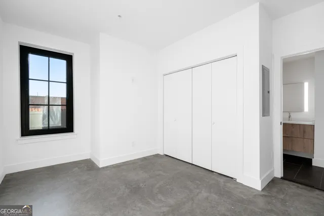 an empty room with windows and closet