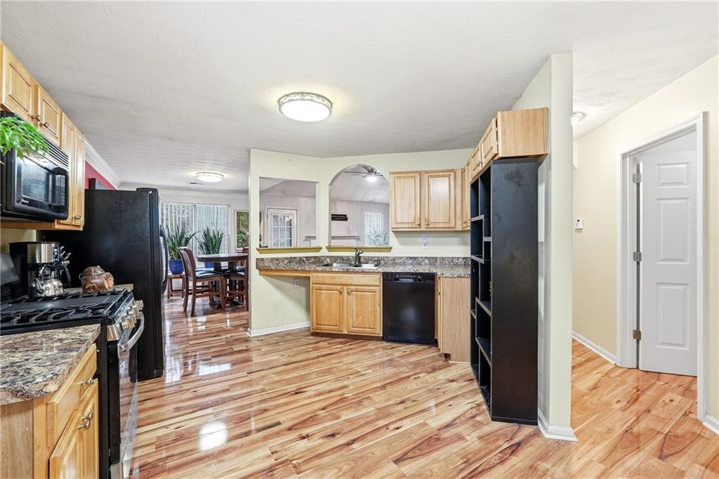 20 Ivans Circle Covington, GA 30016 - Photo 16 of 29 a kitchen with stainless steel appliances granite countertop a refrigerator oven a sink dishwasher and white cabinets with wooden floor