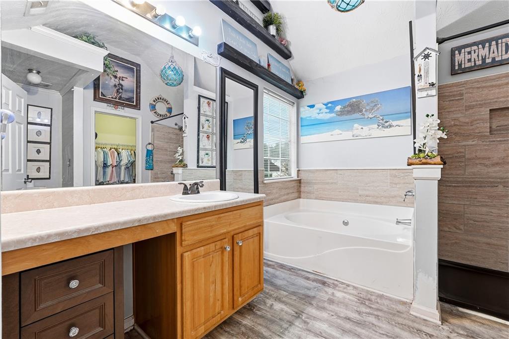 20 Ivans Circle Covington, GA 30016 - Photo 20 of 29 a spacious bathroom with a sink a large mirror and a bathtub