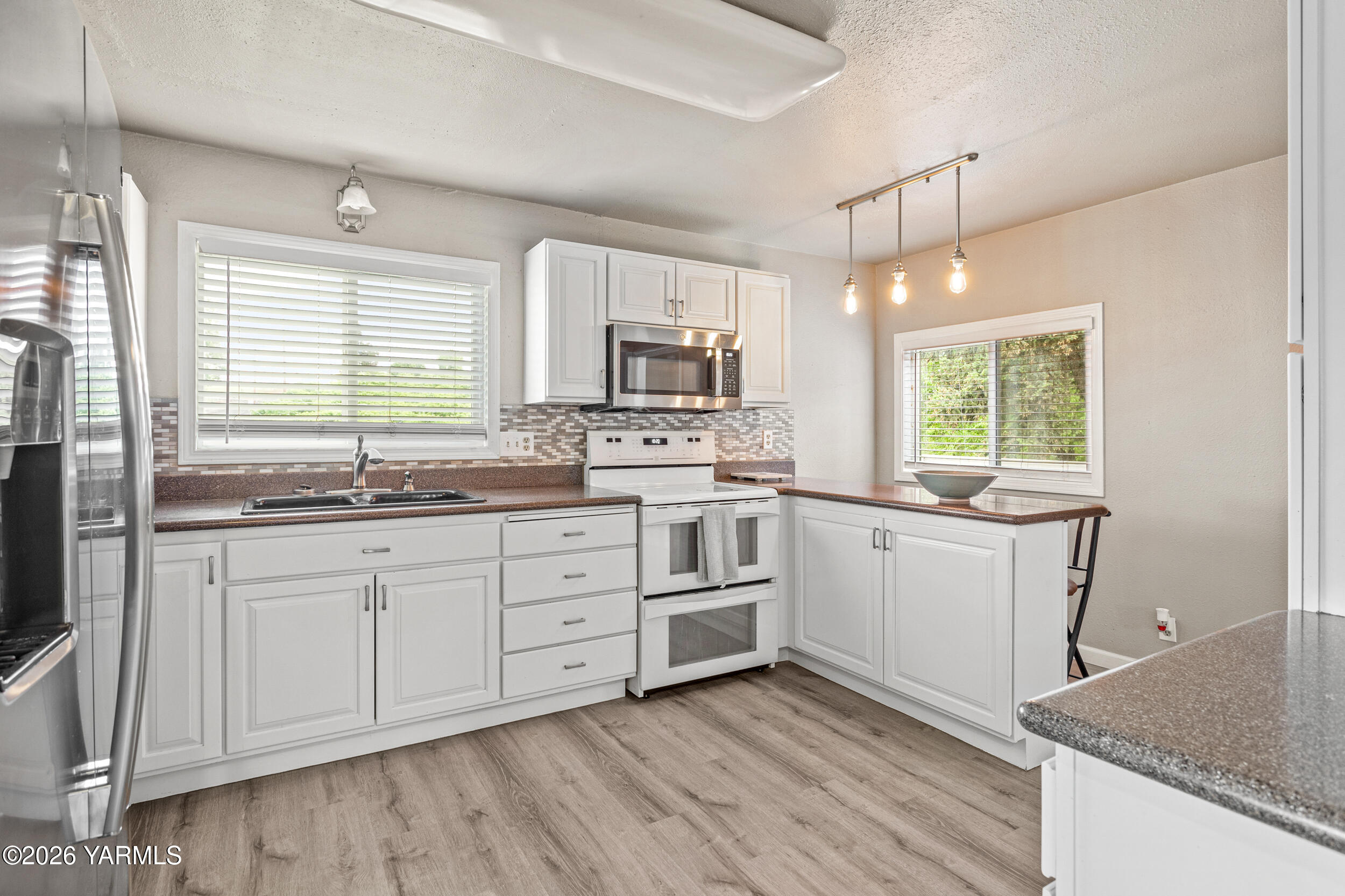 2121 Pleasant Hill Road Selah, WA 98942 - Photo 13 of 38 a kitchen with granite countertop white cabinets white stainless steel appliances a sink and a window