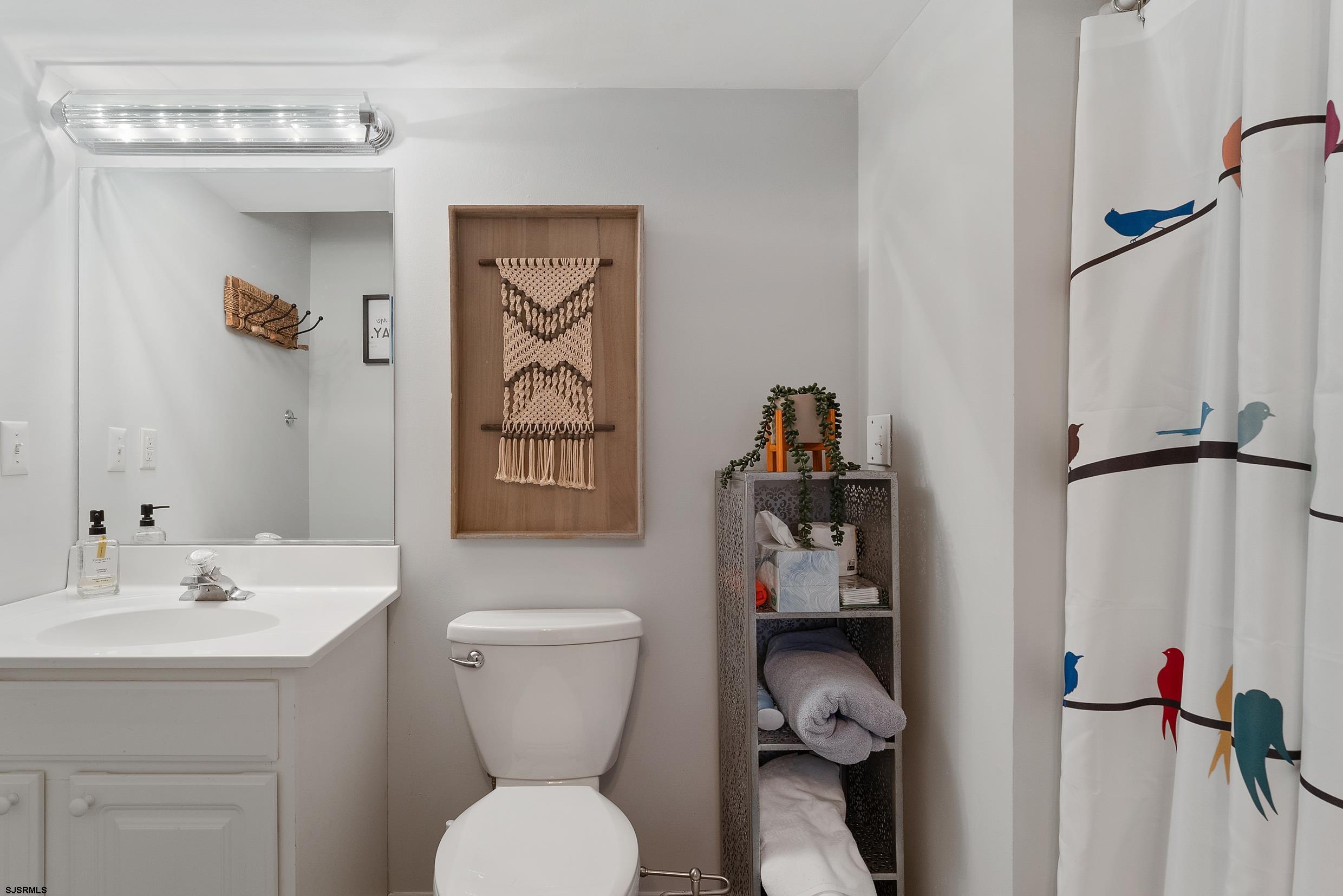 102 Broadway, Unit 2 Somers Point, NJ 08244 - Photo 11 of 98 a bathroom with a toilet sink and mirror