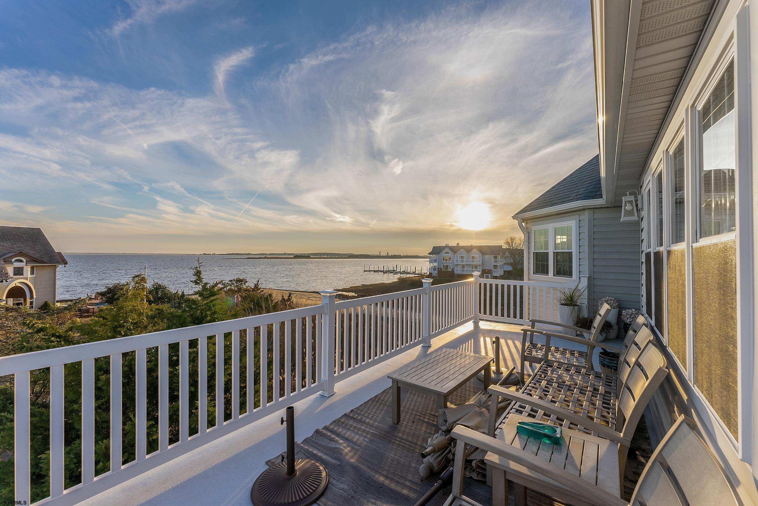 102 Broadway, Unit 2 Somers Point, NJ 08244 - Photo 32 of 98 a view of a balcony with wooden chairs and iron fence