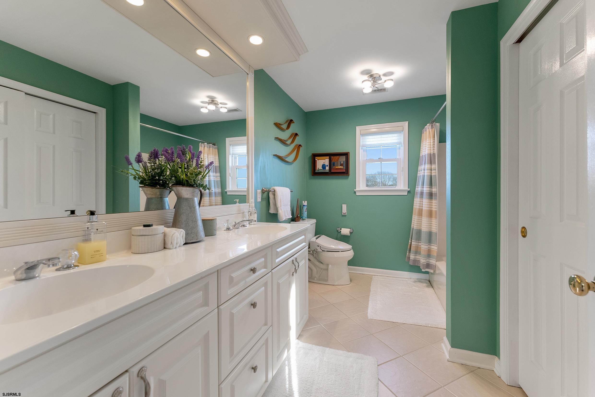 102 Broadway, Unit 2 Somers Point, NJ 08244 - Photo 61 of 98 a spacious bathroom with a double vanity sink a large mirror and a bathtub