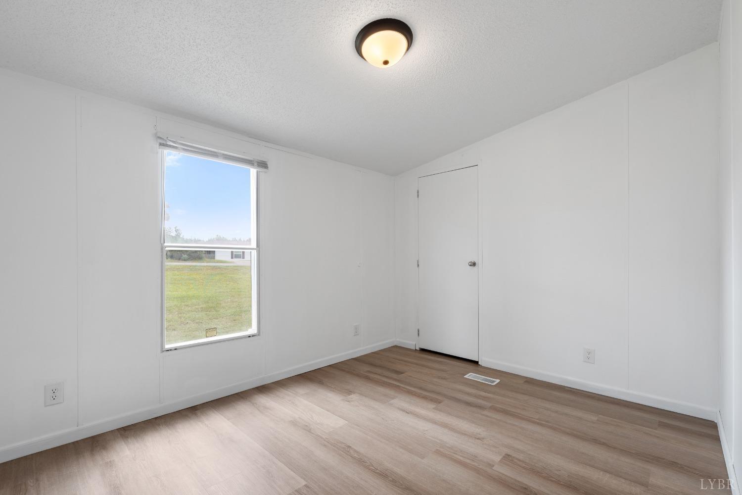 128 Douglas Drive Dry Fork, VA 24549 - Photo 27 of 45 an empty room with wooden floor and windows