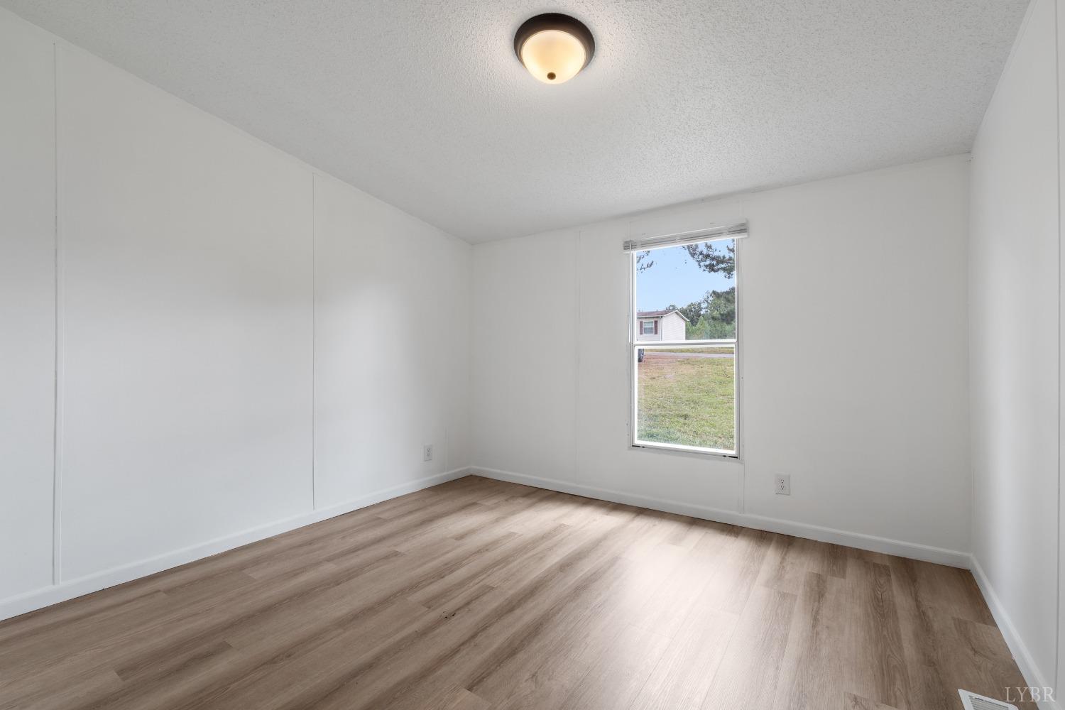 128 Douglas Drive Dry Fork, VA 24549 - Photo 29 of 45 an empty room with wooden floor and windows