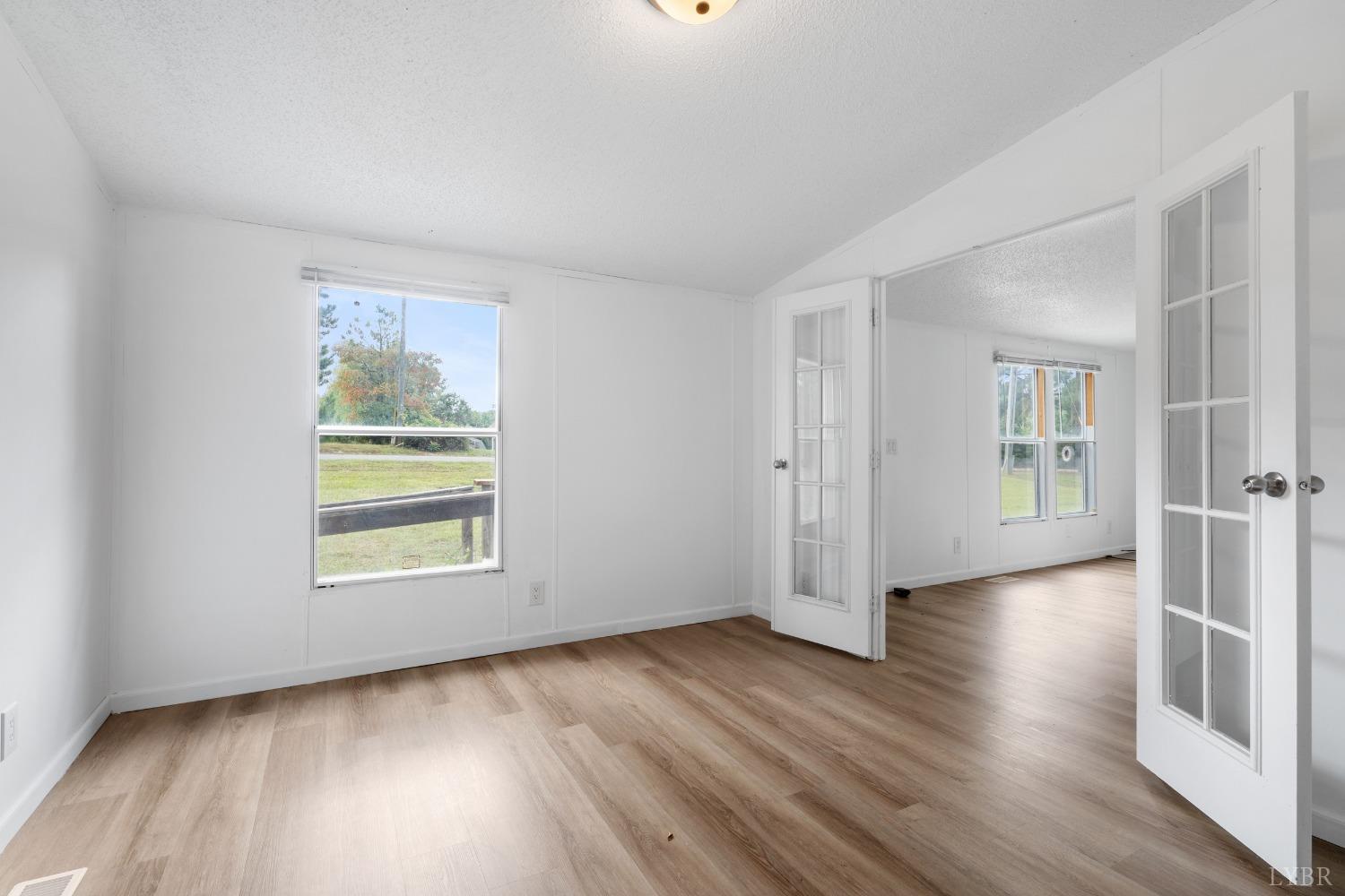128 Douglas Drive Dry Fork, VA 24549 - Photo 7 of 45 an empty room with wooden floor and windows