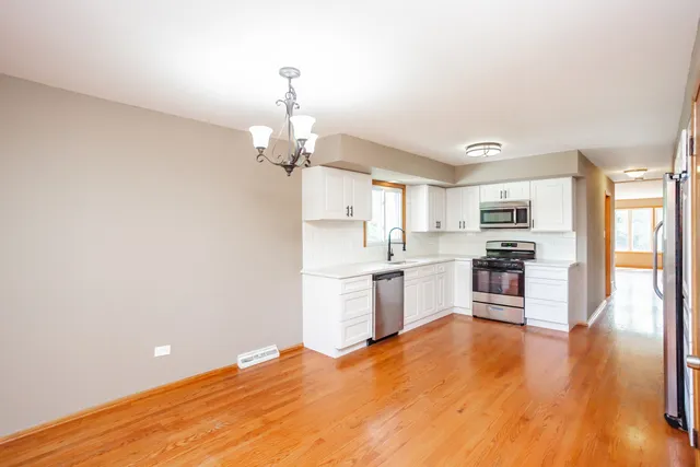 a kitchen with granite countertop a refrigerator stove top oven and sink