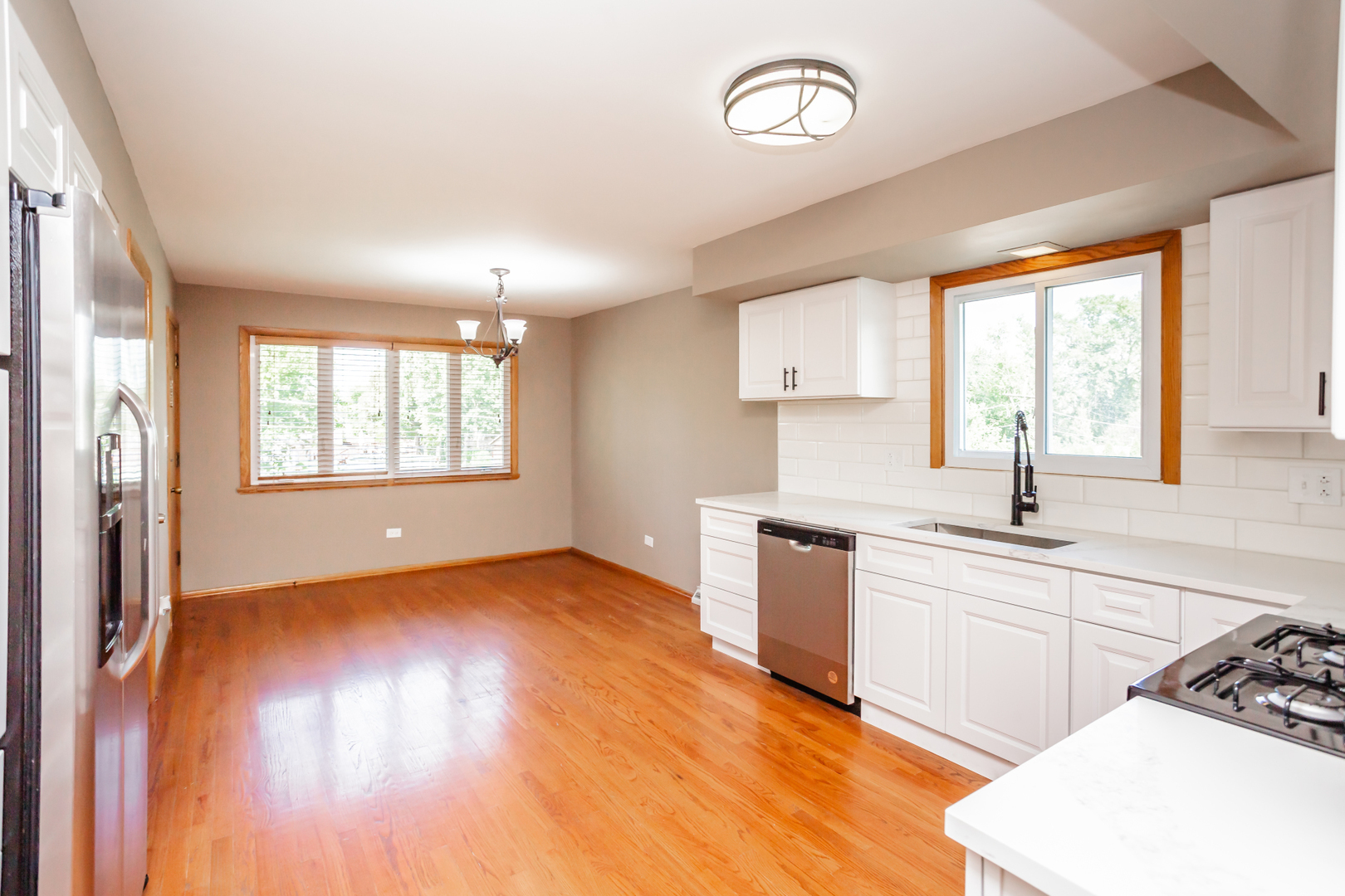 7840 Cronin Avenue, Unit 2 Justice, IL 60458 - Photo 10 of 20 a kitchen with granite countertop a stove a sink and a window