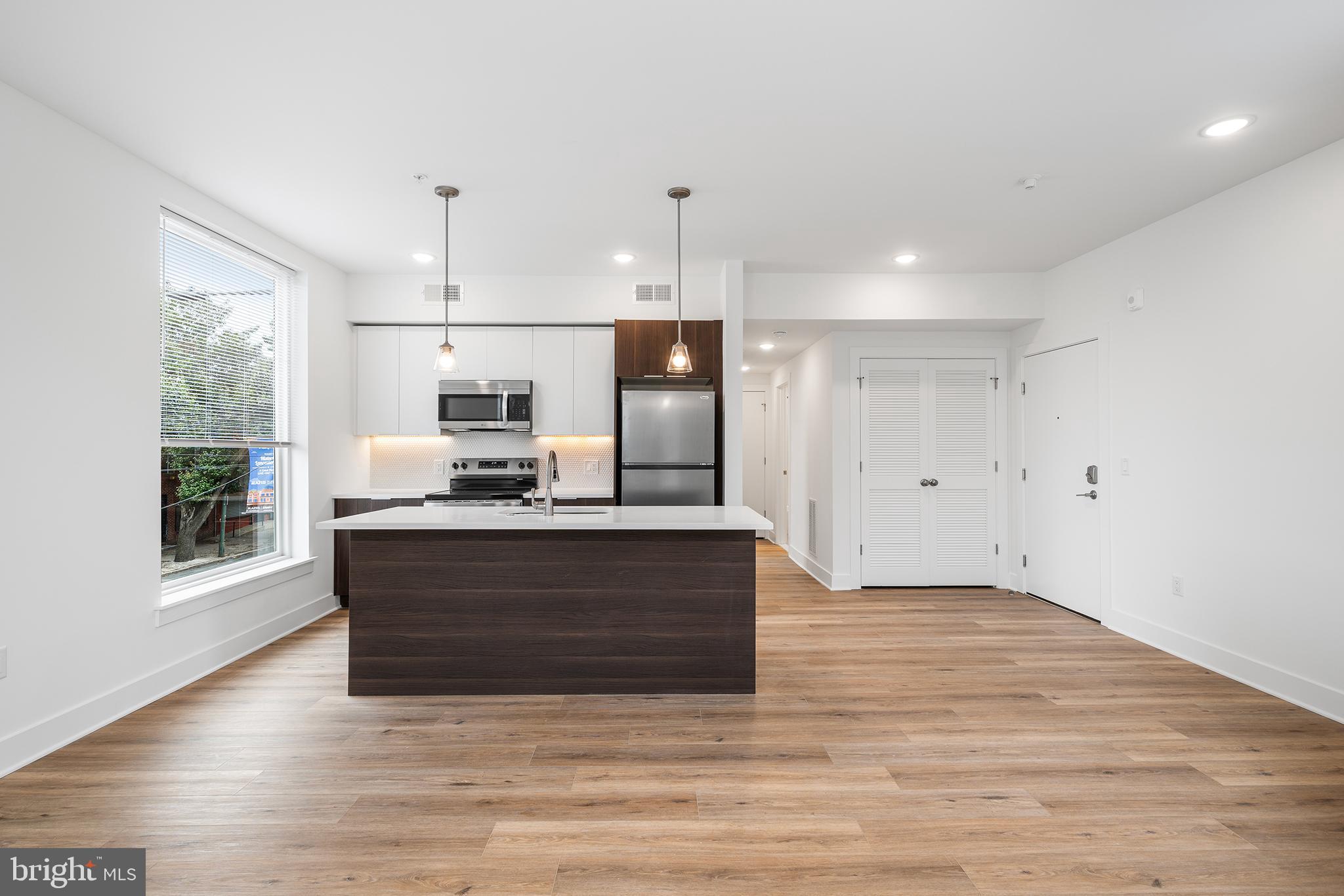 4324 Lancaster Avenue, Unit 100 Philadelphia, PA 19104 - Photo 5 of 19 a view of kitchen with granite countertop stainless steel appliances refrigerator oven and cabinets