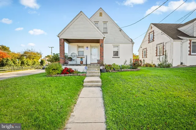 a front view of a house with a yard and trees
