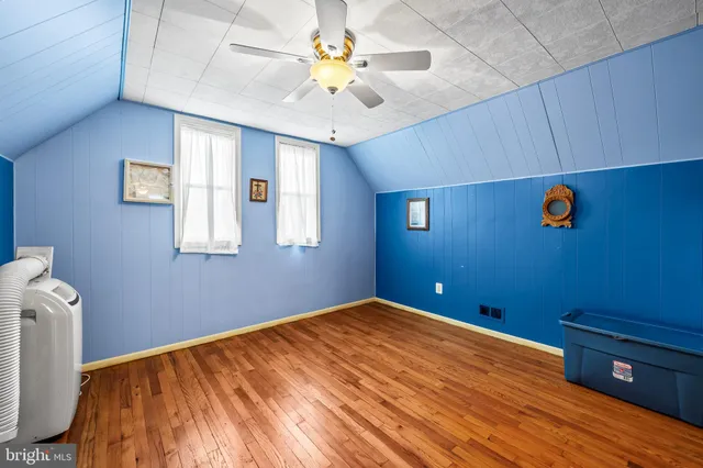 a bedroom with a bed and a chandelier fan