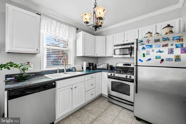 a kitchen with stainless steel appliances granite countertop a sink a stove a microwave a refrigerator and cabinets