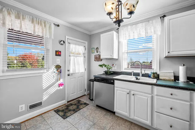 a very nice looking kitchen with granite countertop a sink a window and a counter space