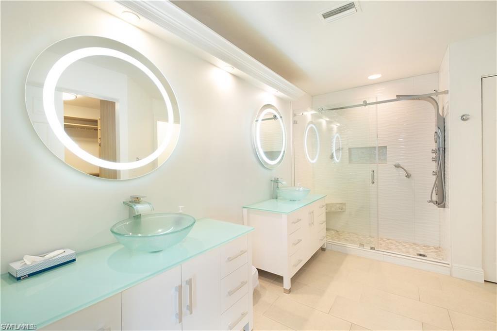 845 Reef Point Circle Naples, FL 34108 - Photo 17 of 41 a bathroom with a double vanity sink mirror and shower
