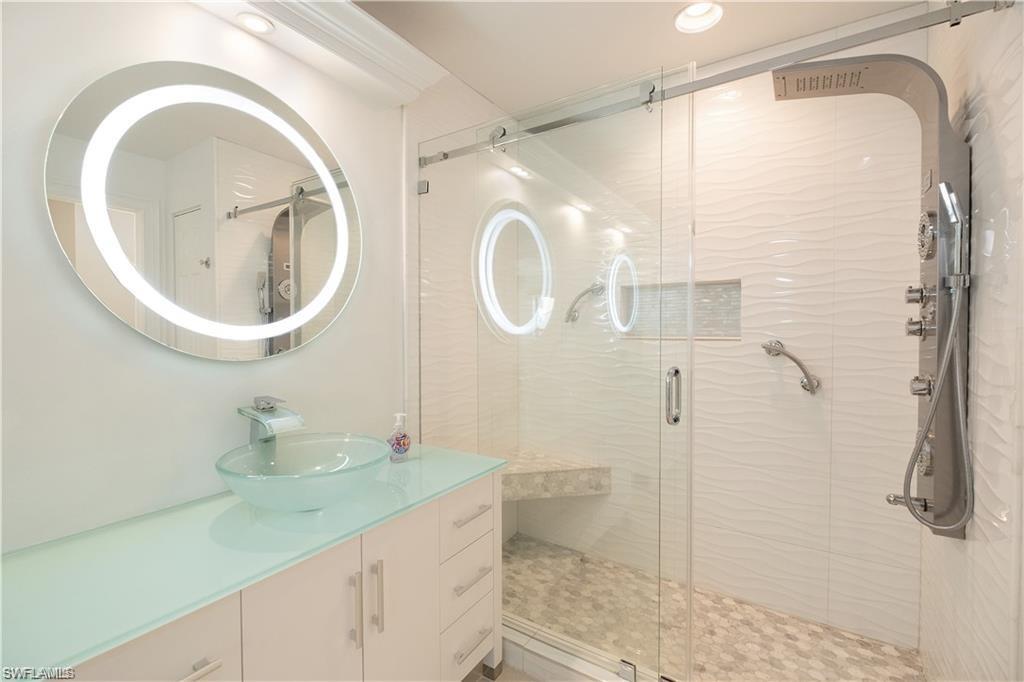 845 Reef Point Circle Naples, FL 34108 - Photo 18 of 41 a bathroom with a granite countertop sink a toilet and a shower