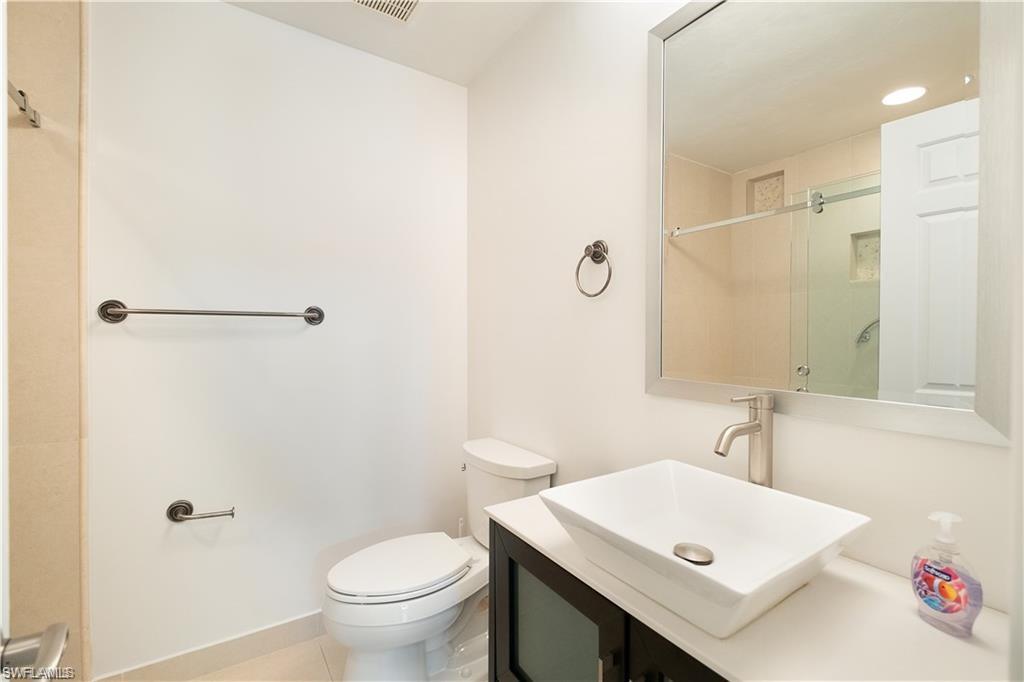 845 Reef Point Circle Naples, FL 34108 - Photo 21 of 41 a bathroom with a sink a toilet and a mirror