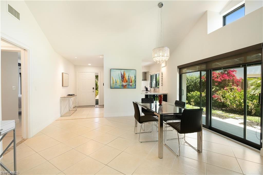 845 Reef Point Circle Naples, FL 34108 - Photo 4 of 41 a view of a dining room with furniture large windows and wooden floor