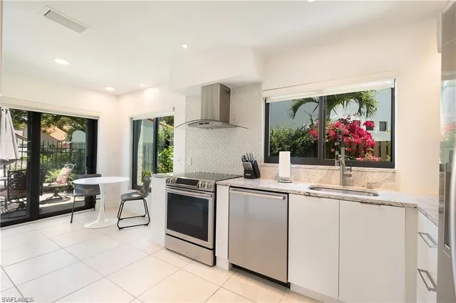 a kitchen with white cabinets and sink