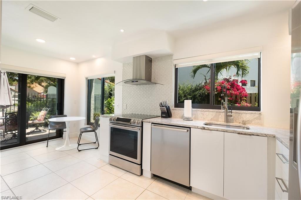 845 Reef Point Circle Naples, FL 34108 - Photo 6 of 41 a kitchen with white cabinets and sink