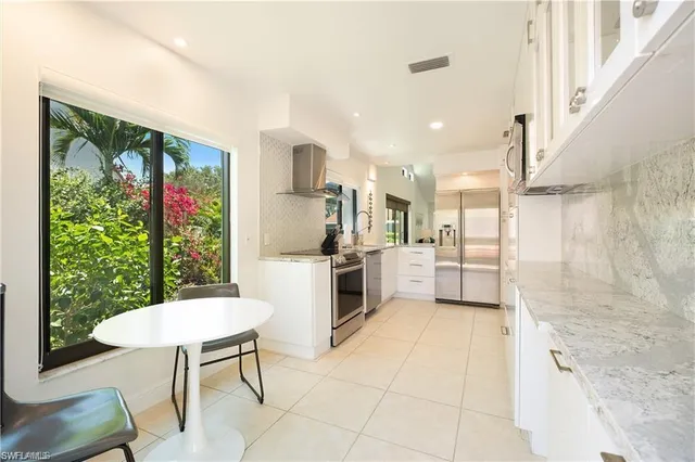 a kitchen with refrigerator and chairs