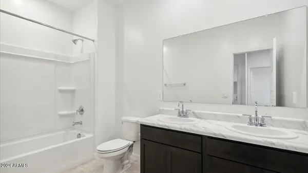 a bathroom with a granite countertop sink a toilet and a bathtub