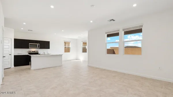 a view of kitchen with stainless steel appliances kitchen island in the middle