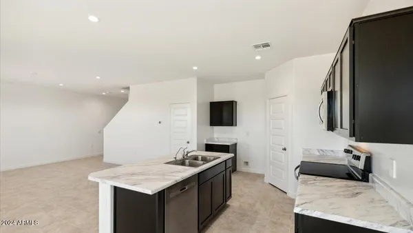 a kitchen with stainless steel appliances kitchen island granite countertop a sink and a refrigerator