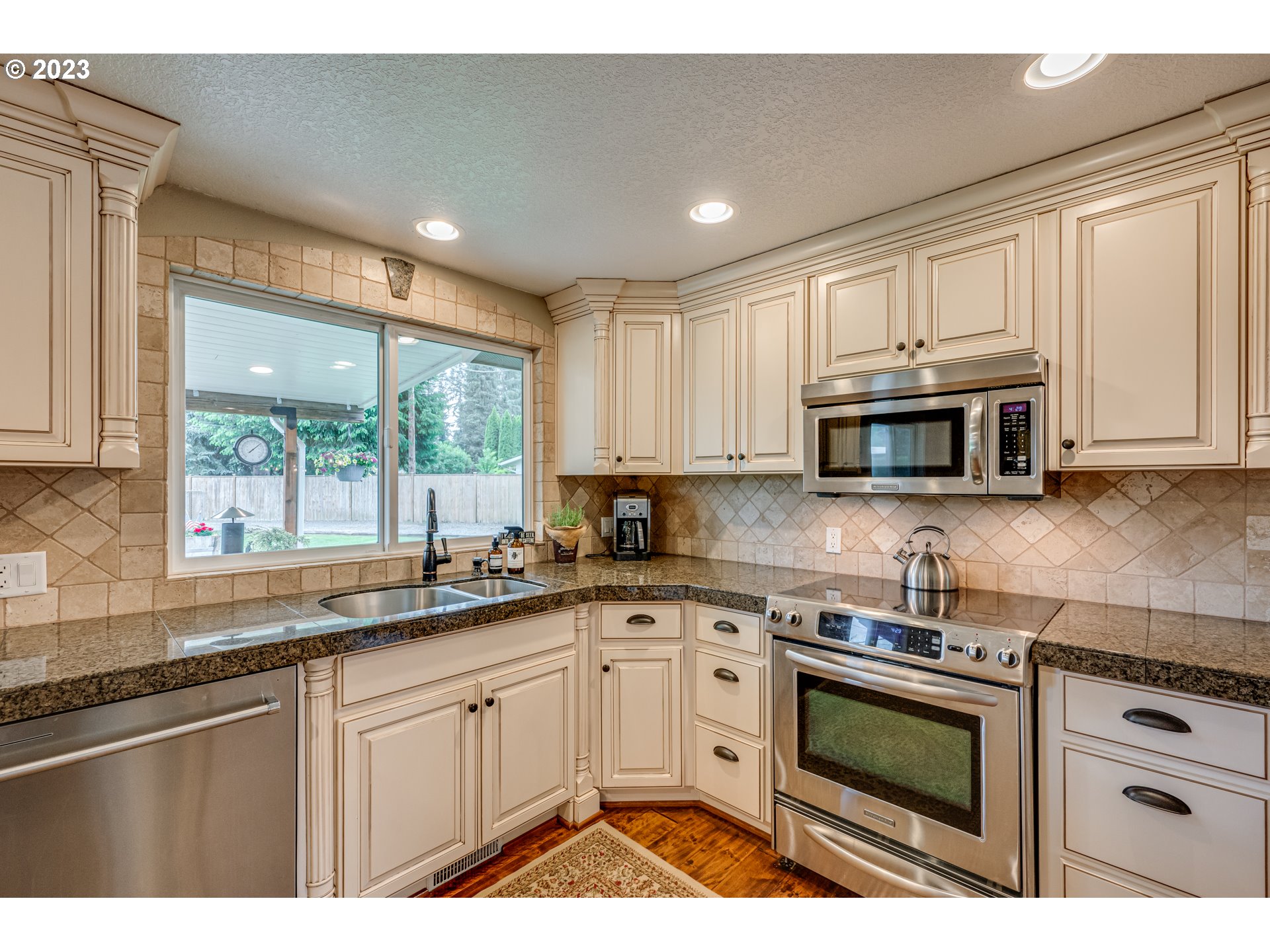 18721 Northeast Cramer Road Battle Ground, WA 98604 - Photo 6 of 32 a kitchen with stainless steel appliances granite countertop a stove a sink and a microwave