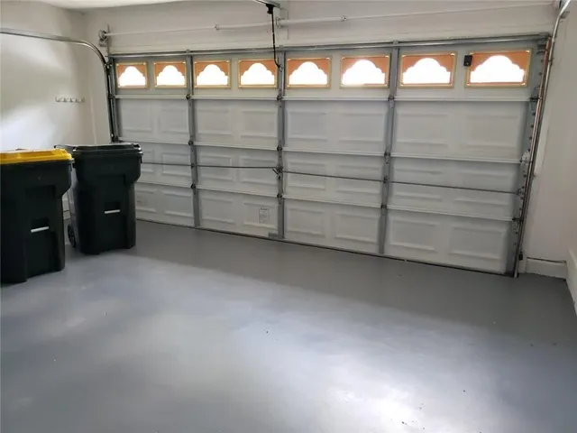 a view of a yard with plants and large tree