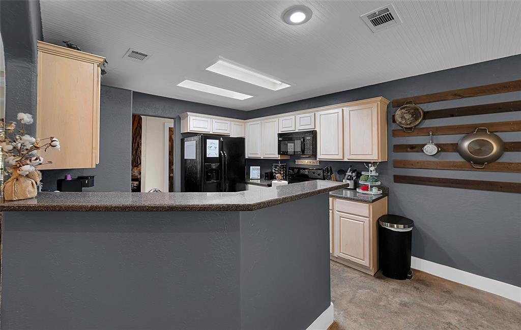 37 Bluebonnet Loop Morgan's Point Resort, TX 76513 - Photo 9 of 38 Kitchen featuring a peninsula counter with stone-finish countertop, light wood cabinetry, recessed lighting, and black appliances