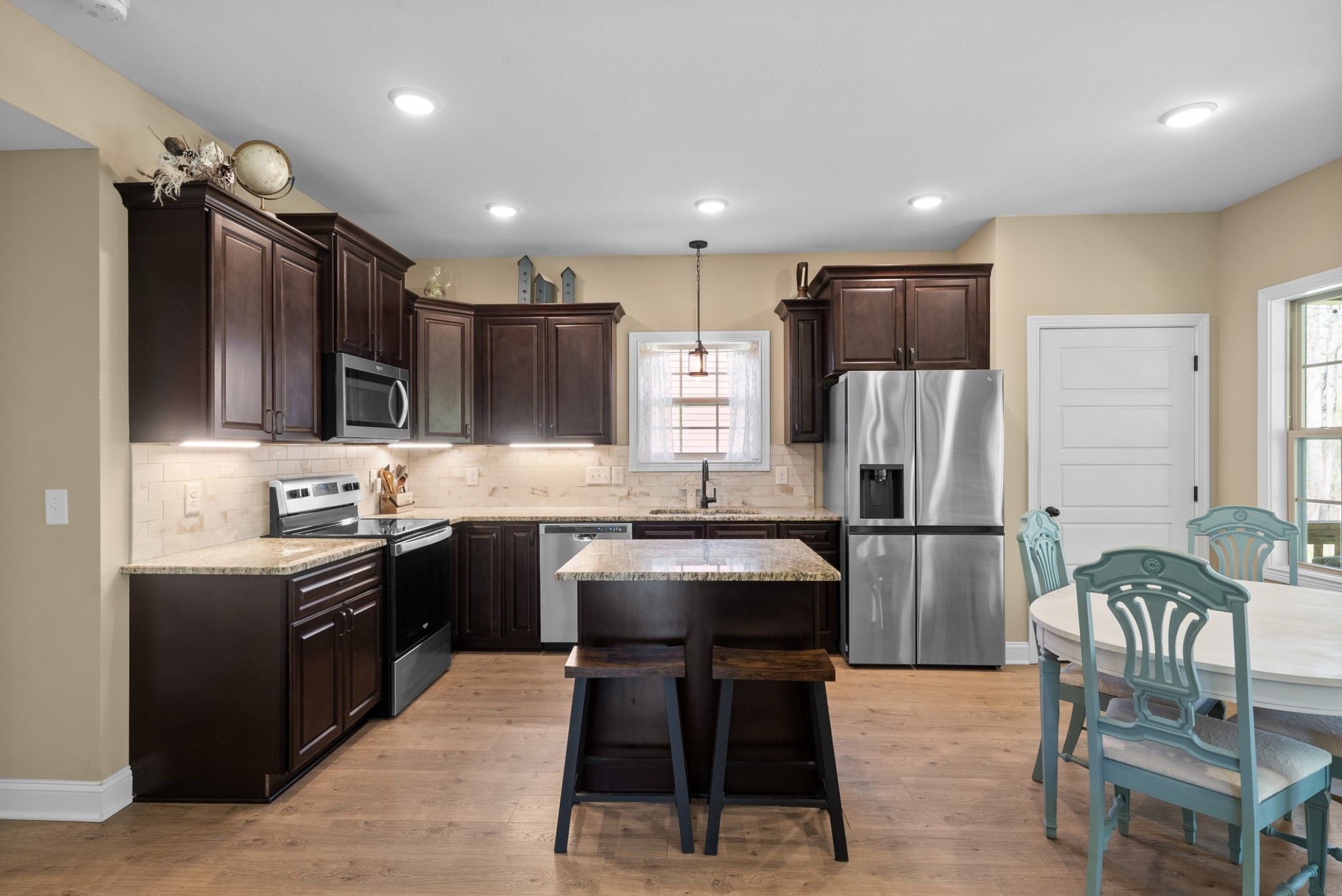 4406 Memory Lane Adams, TN 37010 - Photo 6 of 36 a kitchen with stainless steel appliances granite countertop a refrigerator a stove a sink a dining table and chairs