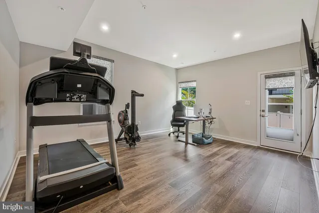 a room with gym equipment and wooden floor
