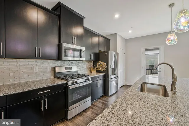 a kitchen with stainless steel appliances granite countertop a stove and a refrigerator