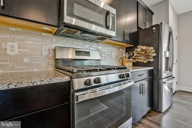 a kitchen with stainless steel appliances granite countertop a refrigerator stove and sink